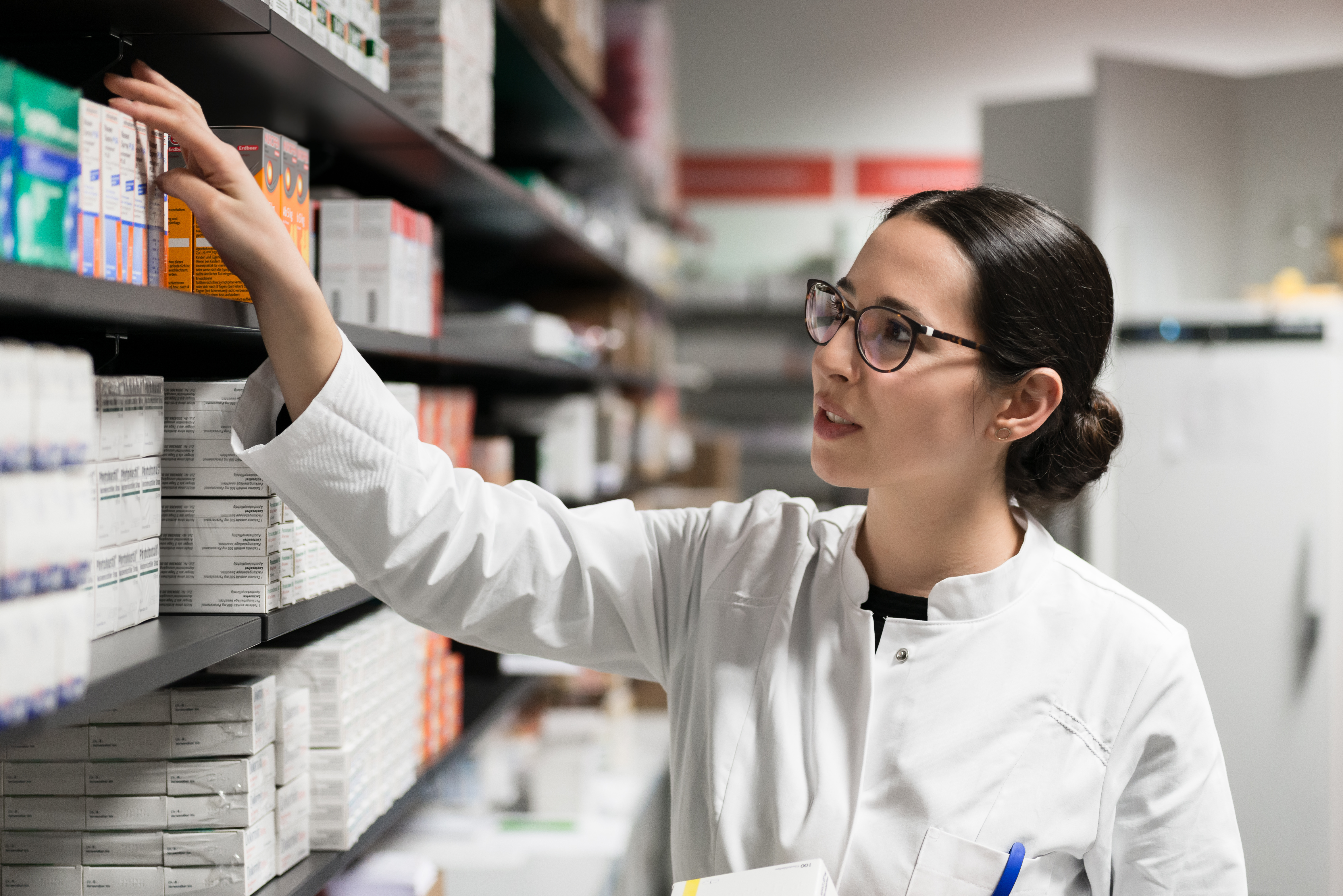 Pharmacist taking medicine from shelf